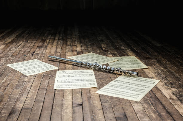 flet leży na drewnianej scenie wśród nut z nutami - musical note sheet music music opera zdjęcia i obrazy z banku zdjęć