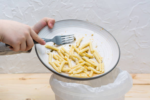 istock Stop wasting food. Leftover lunch is dumped in the bin. Food waste concept. 1205362600