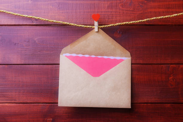 Valentines day concept with envelope and pink blank card hanging on a rope