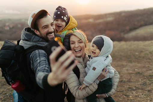Photo of a happy family making a selfie in the nature