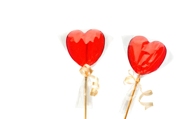 Lollipop. Two  red heart-shaped  lollipops  in transparent packaging on a white isolated background for Valentine's Day. Isolate.