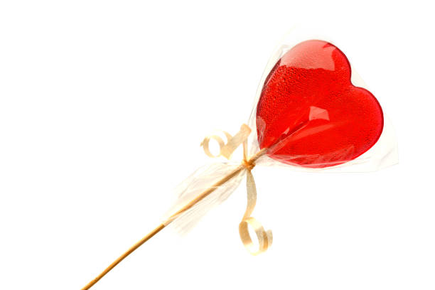 istock Lollipop. One red heart-shaped Lollipop in a transparent package  on a white isolated background for Valentine's Day. Isolate. 1205365833