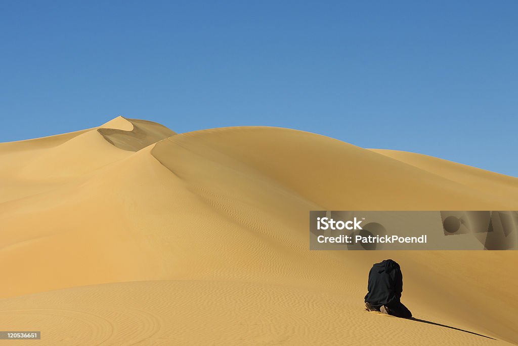 Man 祈る、サハラ砂漠での、リビア - リビア - 北アフリカのロイヤリティフリーストックフォト
