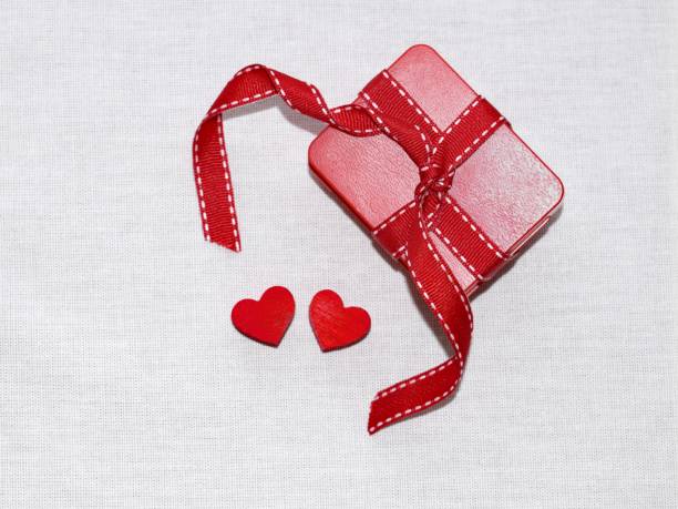 istock Gift box with ribbon and two hearts 1205367477
