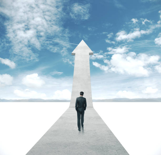istock Businessman in suit walking on gray arrow 1205368180