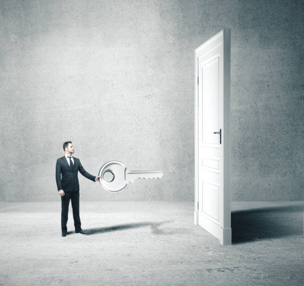 istock Businesman in suit holding big key 1205368293