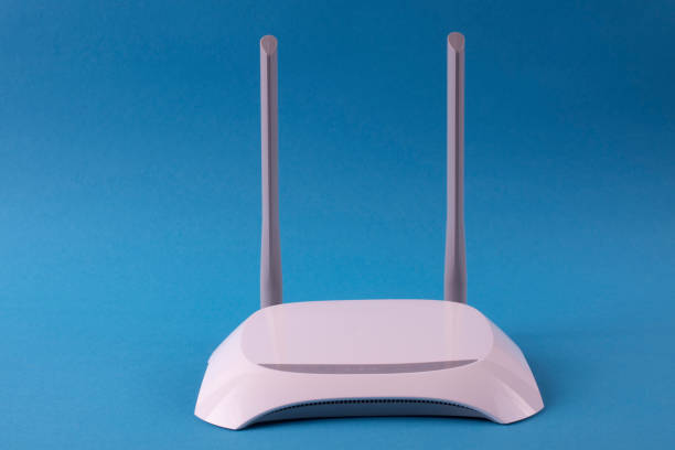 istock White wi-fi router on a blue background. 1205368354