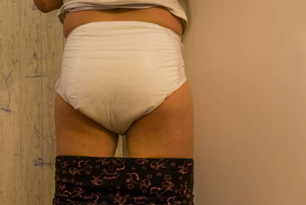 giovane adulto che indossa un pannolino adulto bagnato, vista posteriore, prodotti e soluzioni di incontinenza, problemi di controllo della vescica medica - urinating women bladder embarrassment foto e immagini stock