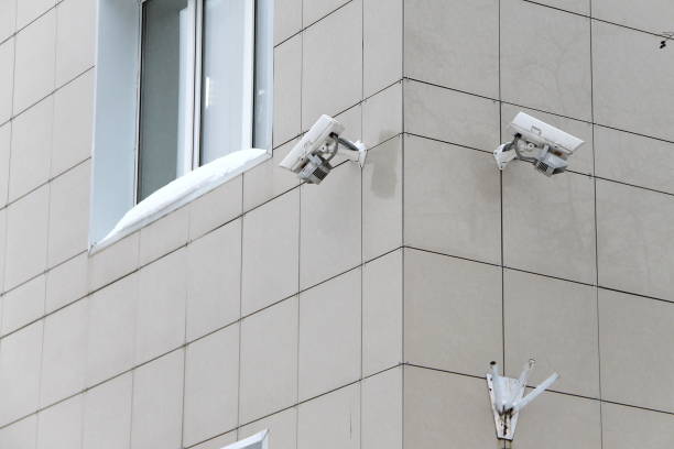 istock Surveillance camera mounted on tiled wall of house 1205369589