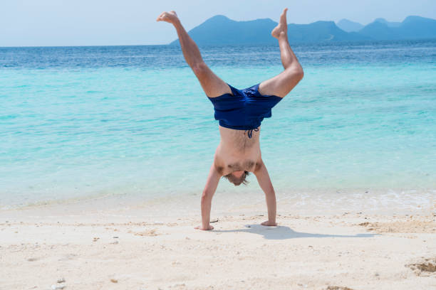 istock Men handstand on the beach 1205370745