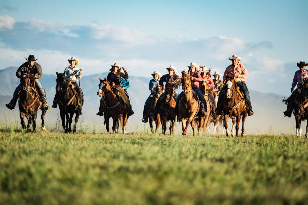 istock Adult cowboys riding galloping horses 1205371656
