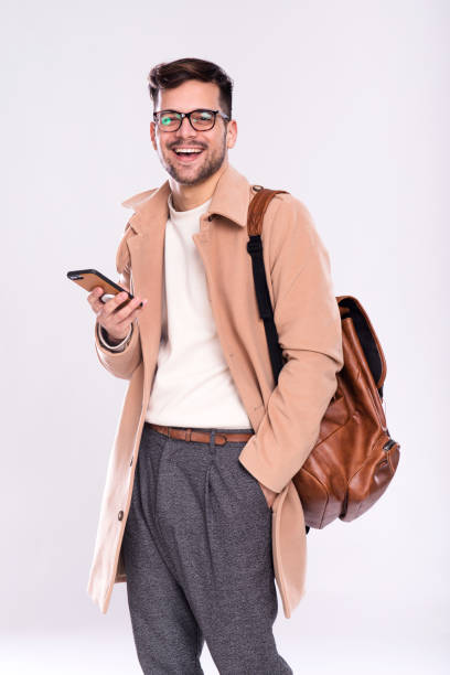 istock Young male standing in studio with cell phone 1205376654