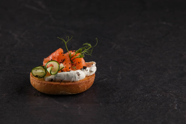 istock Round Italian bruschetta with fish, tomatoes, cream cheese and vegetables. Copy space 1205376712
