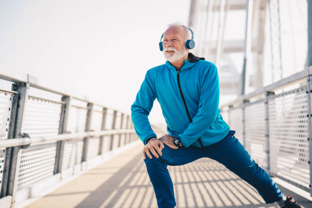 istock An elderly man exercising on a bridge wearing headphones. 1205377554