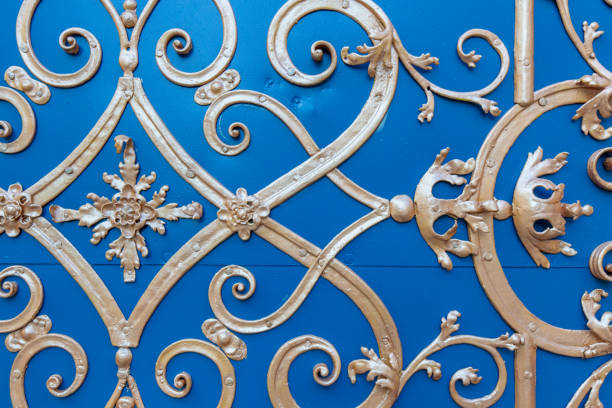 Golden ornaments on old blue door from a university church in Wrocław, Poland. Close-ups of details and surface.
