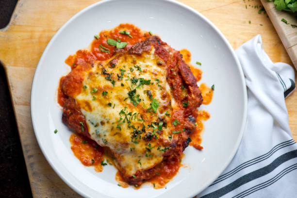 parmigiana di pollo piatto comfort tradizionale italiano. petto di pollo ricoperto di pangrattato leggermente fritto, condito con marinara fatta in casa, mozzarella fusa, provolone di parmigiana e prezzemolo italiano. - chicken baked chicken breast breaded foto e immagini stock