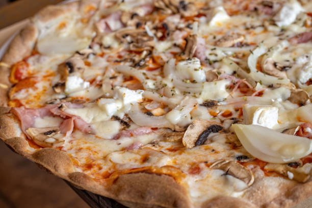 istock Mushroom and ham pizza on the table in the restaurant 1205385274