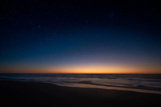 Amazing panoramic view of the Milky Way vanishing above the coast line of the Atlantic Ocean stock photo