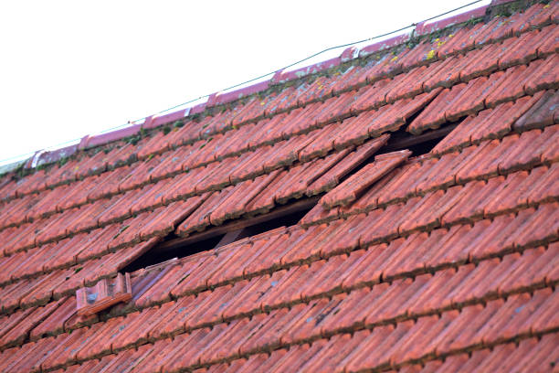 istock Home roof damage after storm. fallen shingles on house 1205391881