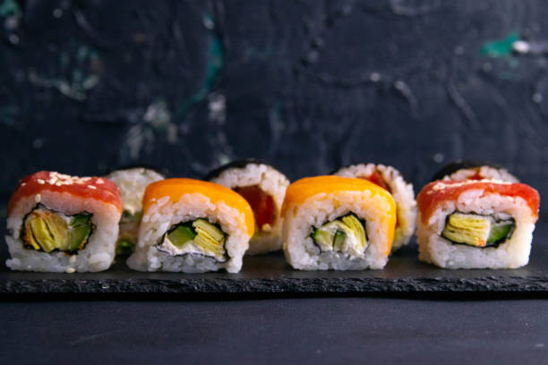 istock Different types of rolls stand on a black granite board for sushi on a black background 1205392084