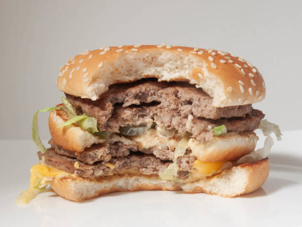 istock half-eaten Burger with two cutlets on a white plate and a light background 1205399208