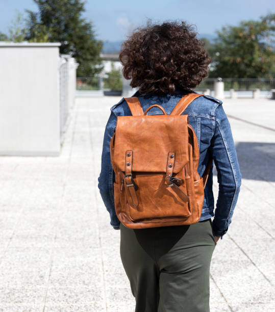 istock Attractive mature woman with backpack walking outdoors 1205400392