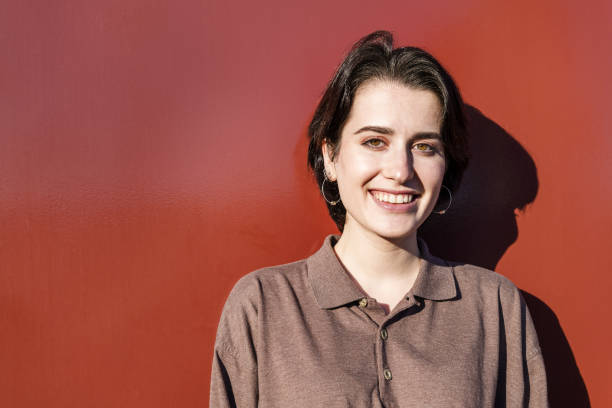istock smiling lovely young woman on a red background 1205401290