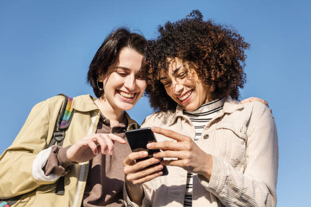 istock two women enjoying funny with the phone 1205401291