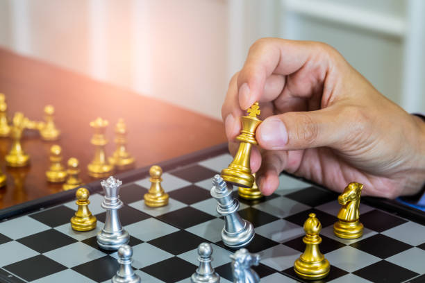 istock Chess game on chess board behind business man background. Business concept to present financial information and marketing strategy analysis. Investment target in global economy and digital commercial. 1205401583