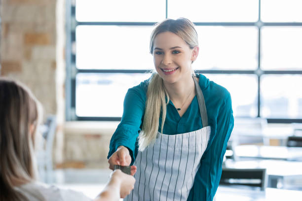 istock Server in local pizza restaurant accepts credit card payment from customer 1205409700