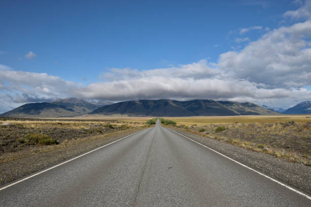 istock asphalt road with mountains and clouds in the background 1205412342