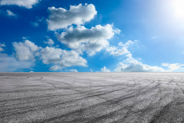 istock Asphalt road and blue sky with white clouds in summer 1205412974