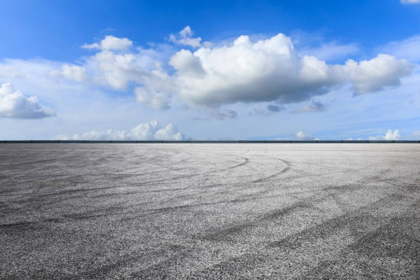 istock Asphalt road and blue sky with white clouds in summer 1205413783