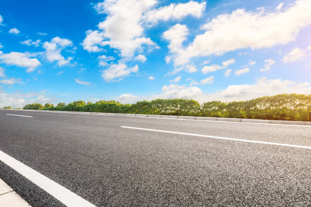 istock Asphalt road and green woods background 1205416198