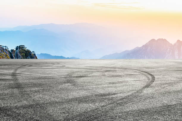 istock Asphalt road and mountains background 1205416314