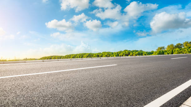 istock Asphalt road and green woods background 1205416412
