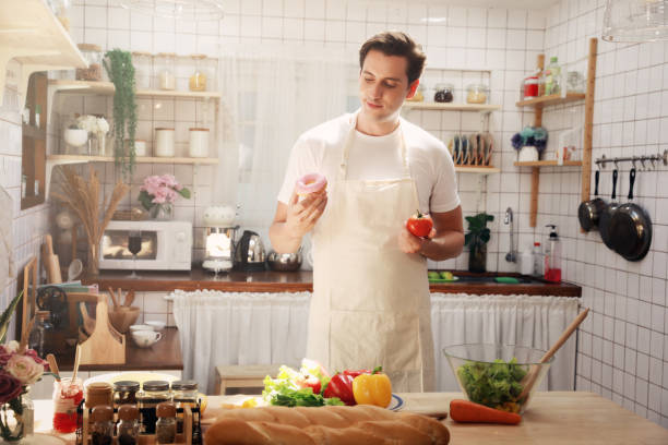 istock The young man chose to eat donuts rather than eating tomatoes because he couldn't resist. 1205417041