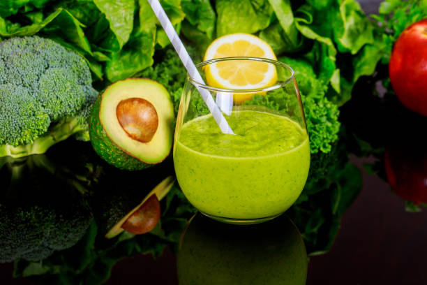 istock Vegetables healty smoothie in glass with straw on black table. 1205418553