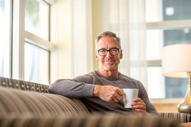 istock Portarit of a handsome older man sitting on a sofa 1205419542