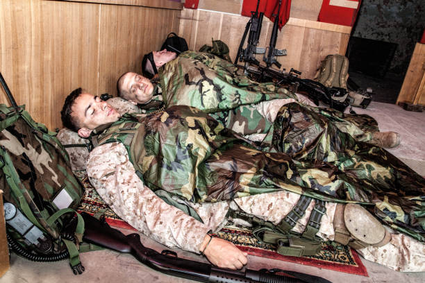 istock Tired soldiers sleeping on floor at temporary base 1205419994