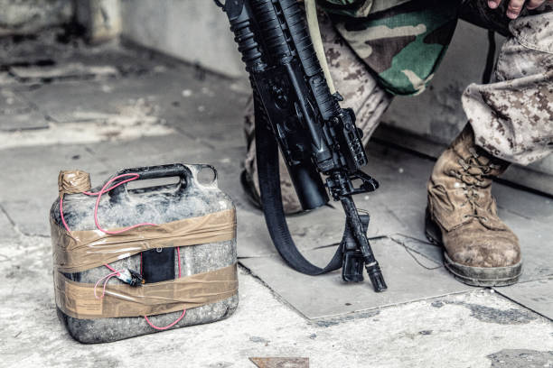 Soldier cuts wire on improvised explosive device Army soldier, anti terrorist team combat engineer, ammunition technical officer, explosives military expert with homemade bomb on floor explosive stock pictures, royalty-free photos & images