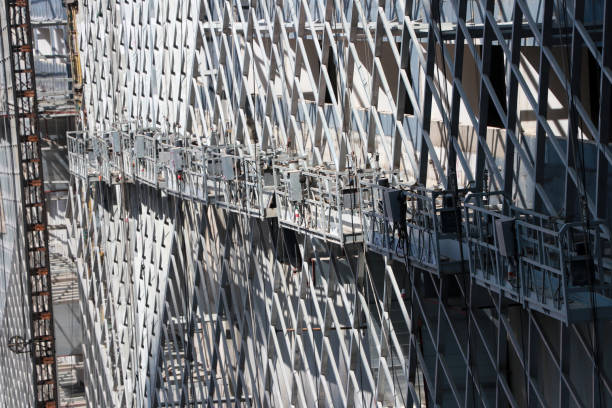 istock hanging scaffold or construction platform outside of a building, being used for construction purpose. 1205422063