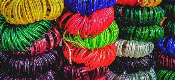 Colorful Bangles A bundle of colorful glass Bangles kept staked up in a street market stall bangle stock pictures, royalty-free photos & images