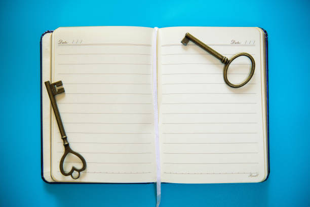 boussole et clé de cru sur le cahier spiralé blanc - spiral notebook ring binder old paper photos et images de collection