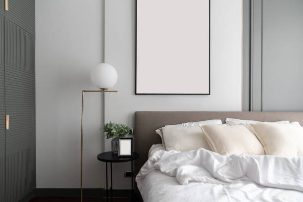 istock Cozy bedroom corner with modern brown fabric bed headboard and comfortable pillows  setting with gold lamp and artificial plant in glass vase on side table /Interior design decoration / copy space 1205432113
