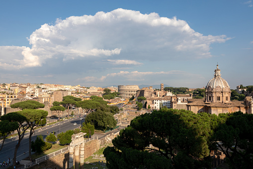 Panoramic view of city Rome with Roman forum and Colosseum from Vittorio Emanuele II Monument also known as the Vittoriano. Summer sunny day and dramatic blue sky