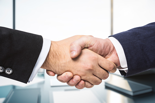 Close-up of two businesspeople shaking hands.