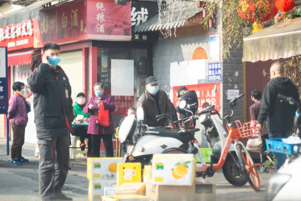 Chinese wearing surgical mask on phone ChengDu China - Feb 11 2020: Since December 2019, Wuhan City, Hubei Province has found multiple cases of viral pneumonia, all of which were diagnosed with viral pneumonia / pulmonary infection.2019-nCoV coronavirus pneumonia in Wuhan has been spreading many cities in China.People wearing surgical mask on phone ChengDu. chengdu photos stock pictures, royalty-free photos & images