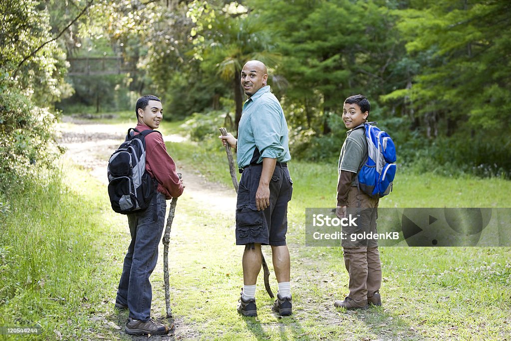 Vista traseira Pai e filhos de escalada na trilha na floresta - Foto de stock de Adulto maduro royalty-free