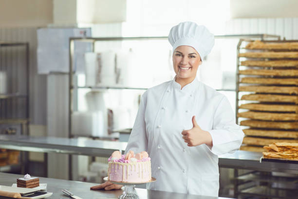 istock Confectioner with pastry cake in his hand at the bakery. 1205445892